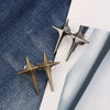 Two gold-toned Y2K star clips for fastening jeans or skirts