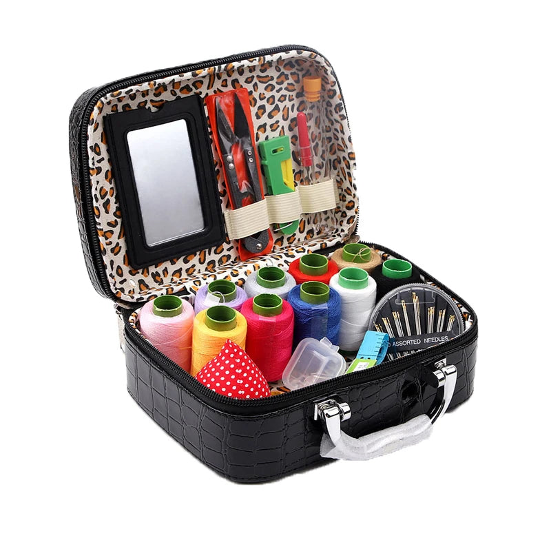 A black leather sewing kit with a leopard print lining, containing various needles and tools.