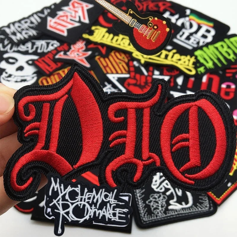 A set of embroidered iron-on patches featuring the stylized letters D I O in red and black on a black fabric background.