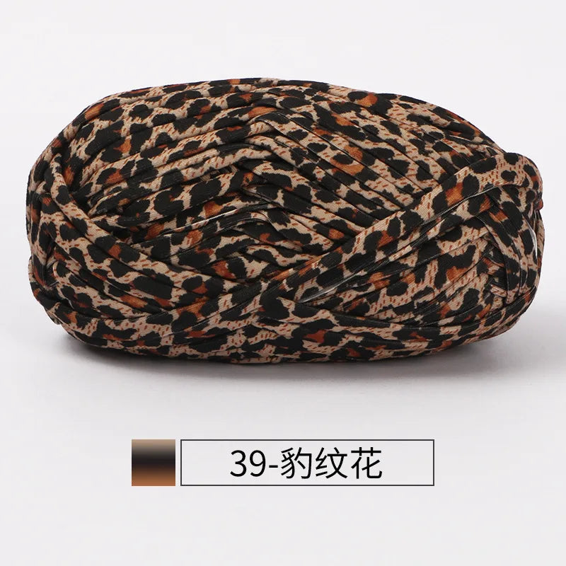 A ball of hand-dyed fabric strip yarn featuring a leopard print pattern.