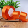 Roll of orange satin ribbon with white filler for gift wrapping and crafts