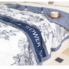 A white and blue floral duvet cover featuring detailed botanical illustrations on a bed.