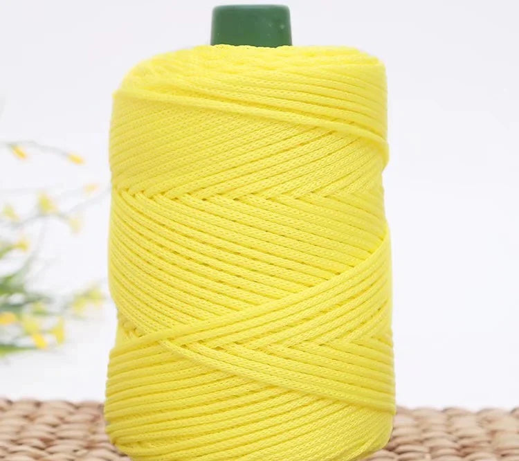 A spool of bright yellow crochet ice rope with a green cap, ready for DIY crafts.