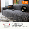 A dark gray Jacquard plush elastic sofa cover with a black cushion displayed on a sofa.