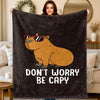 A dark gray plush flannel blanket featuring a cartoon drawing of a bear wearing sunglasses with the text Don't Worry Be Capy