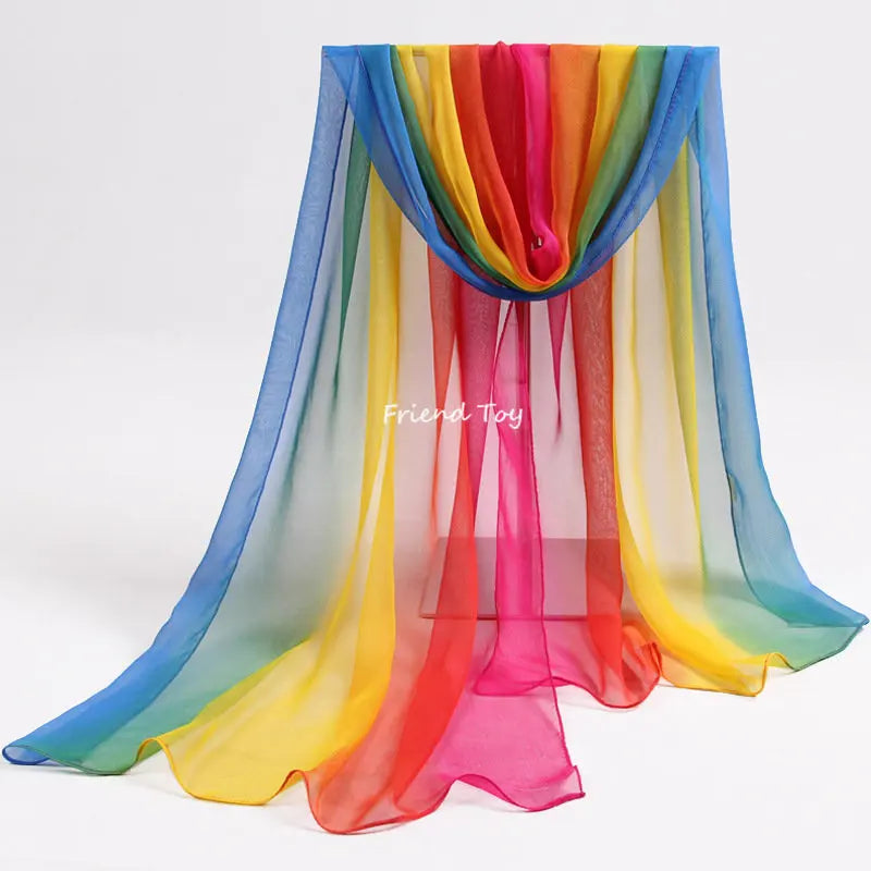 A colorful, sheer fabric scarf displayed in a vertical drape, featuring a rainbow gradient of colors.