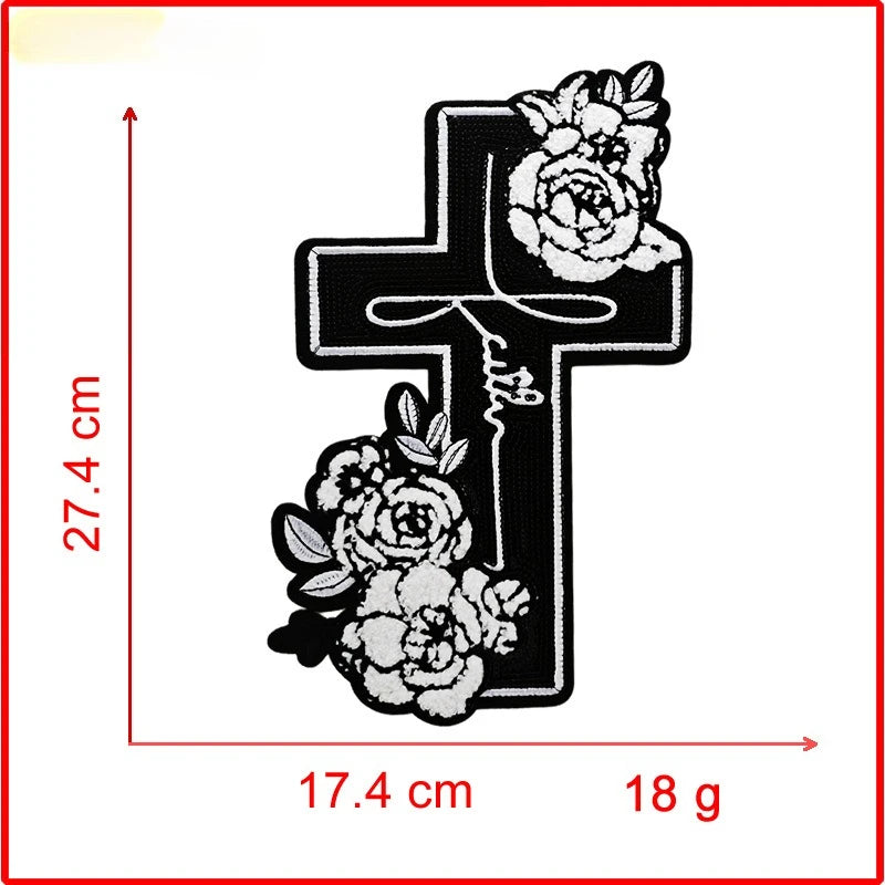 Black iron-on embroidery patch shaped like a cross with roses, measuring 27.4 cm high and 17.4 cm wide.