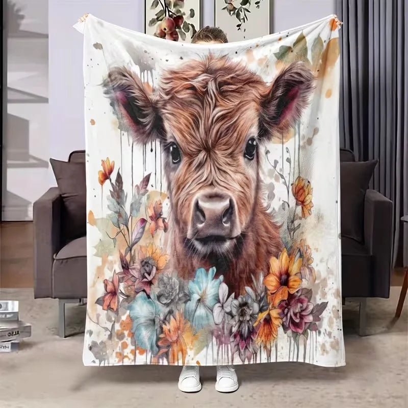 A flannel blanket featuring a watercolor painting of a Highland cow with autumnal floral accents.