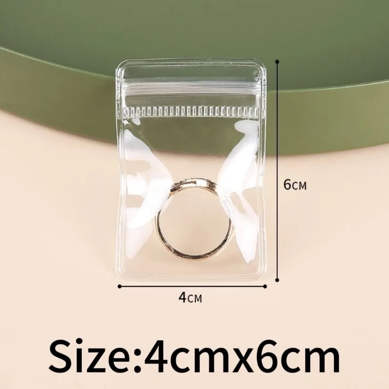Clear plastic jewelry storage bag with a silver ring inside, measuring 4cm by 6cm.