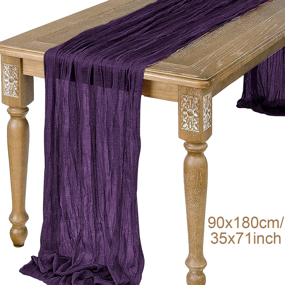 A purple semi-sheer gauze table runner draped over a wooden table.
