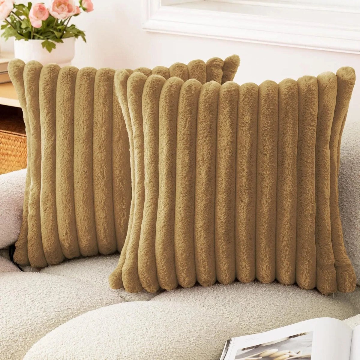 A rectangular cushion cover made of faux rabbit fur in a muted olive green color resting on a light-colored sofa.