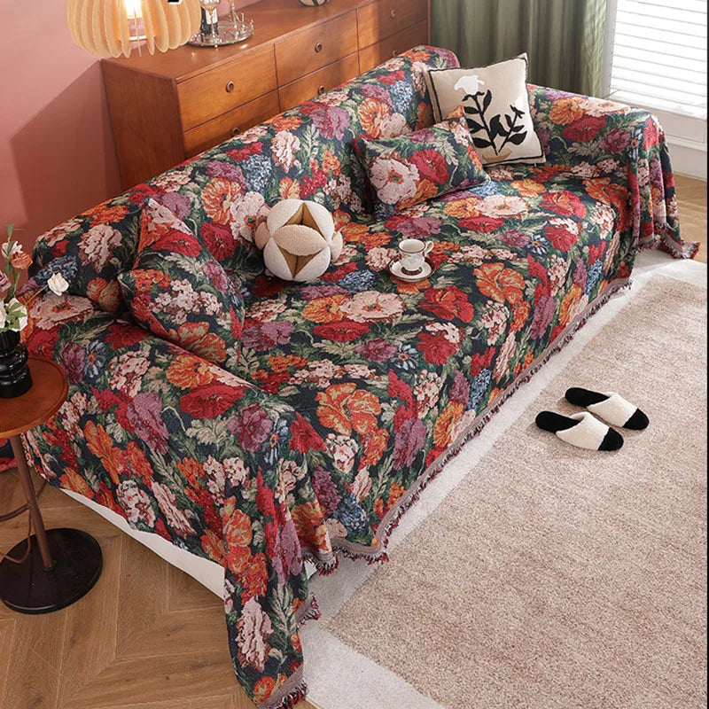 A romantic floral jacquard sofa throw blanket draped over a sofa with decorative pillows.