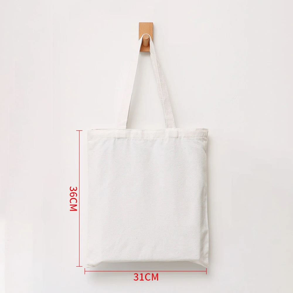 A white canvas tote bag with wooden handles is displayed against a white background.
