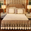 A beige and gold 3-piece bed skirt set with decorative lace trim and matching pillowcases on a bed.
