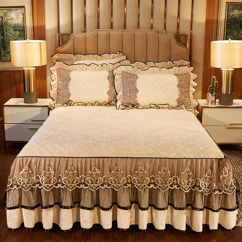 A beige and gold 3-piece bed skirt set with decorative lace trim and matching pillowcases on a bed.