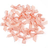 A collection of light pink satin ribbon bows for craft and decoration.