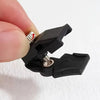 A hand holds a black zipper repair kit with five detachable pulls, showing the components for repairing bags and coats.