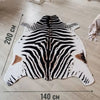 A rectangular rug featuring a black and white zebra print on a white background.