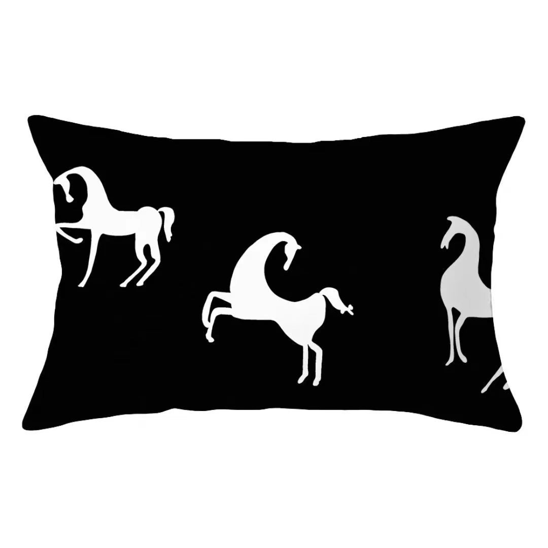 A black decorative pillow cover featuring white silhouettes of horses.