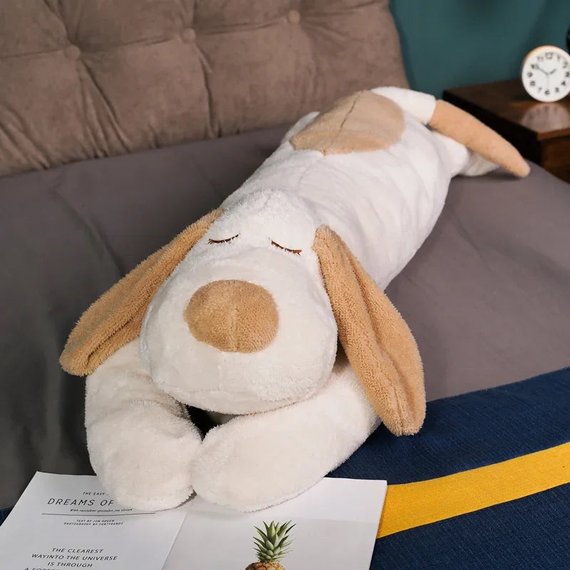 A white and tan giant soft cotton dog plush pillow doll resting on a gray surface.