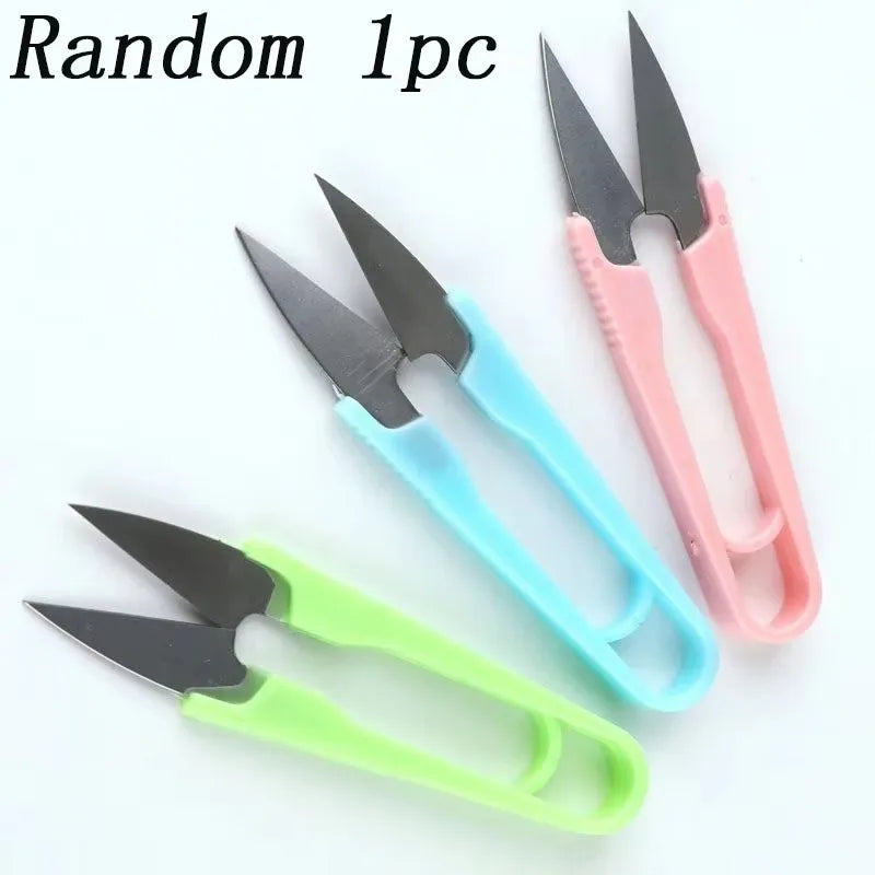 A set of three pink and teal U-shape sewing scissors for cutting yarn, fabric, and needlework.