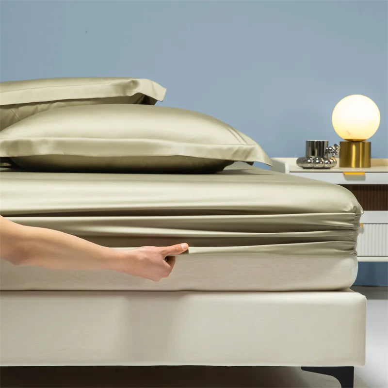 A hand adjusts a beige luxury bamboo bedding set on a light-colored bed.