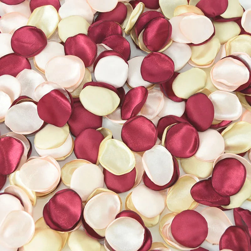 A close-up view of a pack of 100 silk rose petals in shades of dusty pink, cream, and deep burgundy.