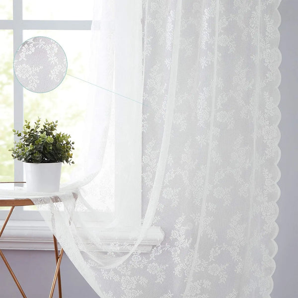 White vintage floral lace curtain panel hanging in a bright window