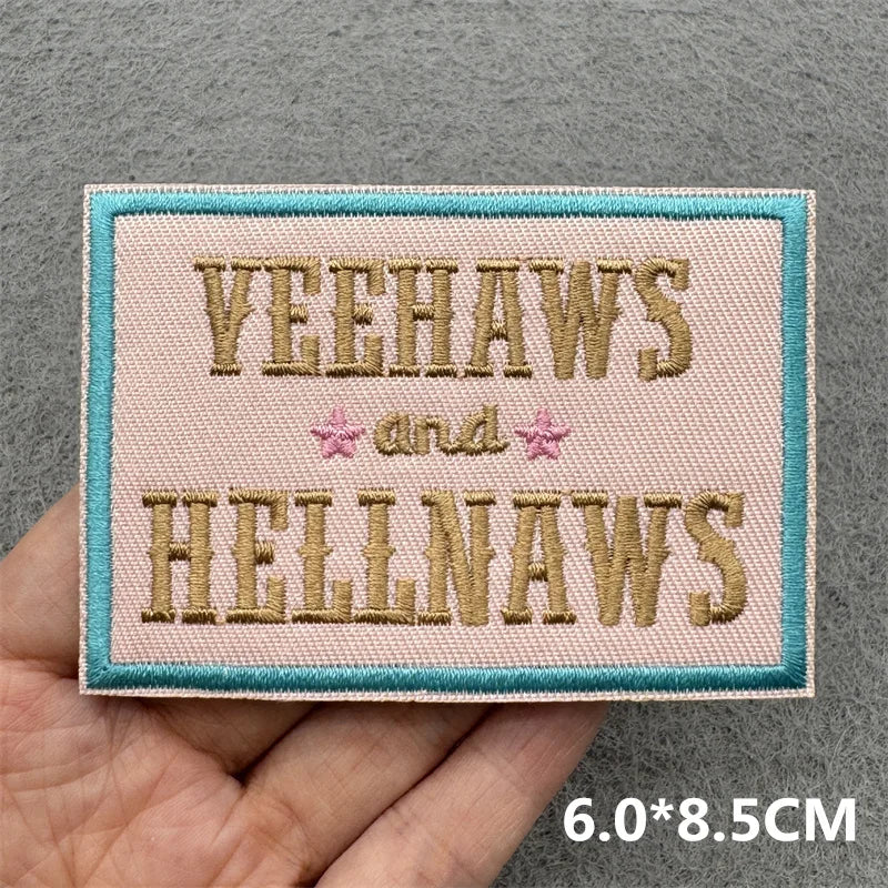 Pink embroidered patch with the text Yeehaws and Hellnaws on a gray background