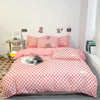 A pink and white checkered duvet cover set displayed on a bed in a bright room.