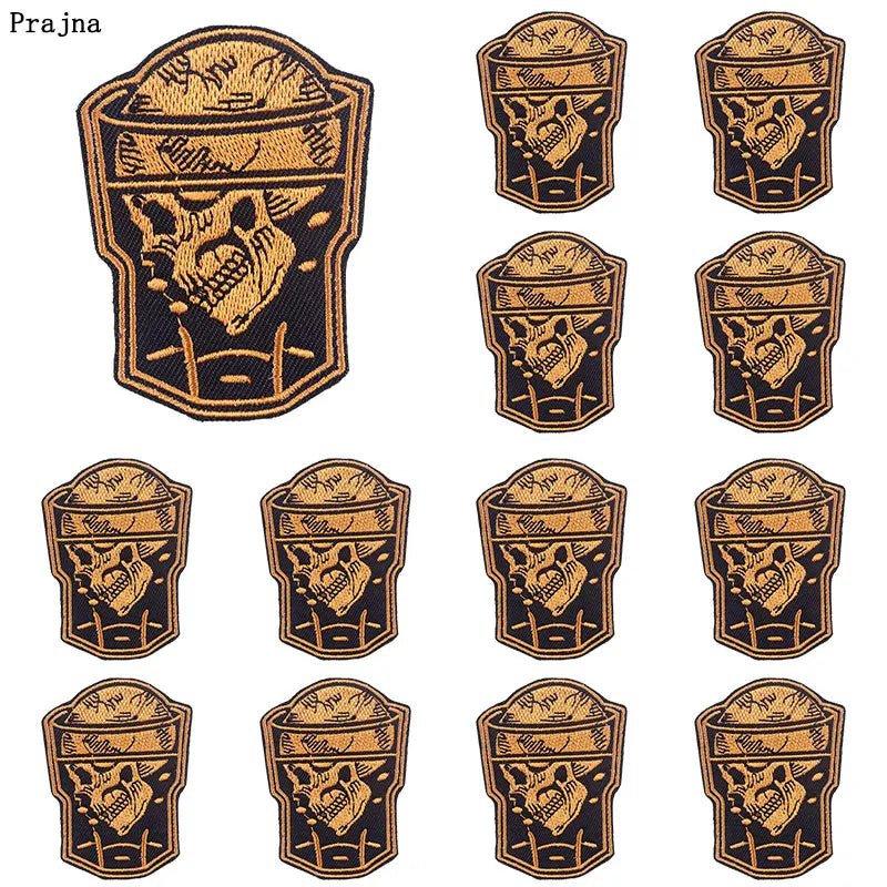 A set of nine black and gold DIY punk embroidery patches featuring skull designs on a fabric background.