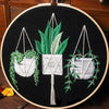 Floral cross stitch embroidery kit featuring green and white foliage designs on black fabric