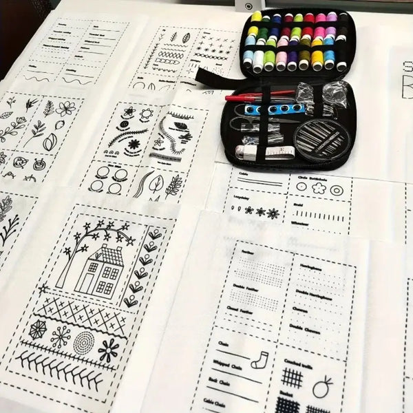 A black embroidery kit with various threads and tools is displayed on a sheet of pattern paper.
