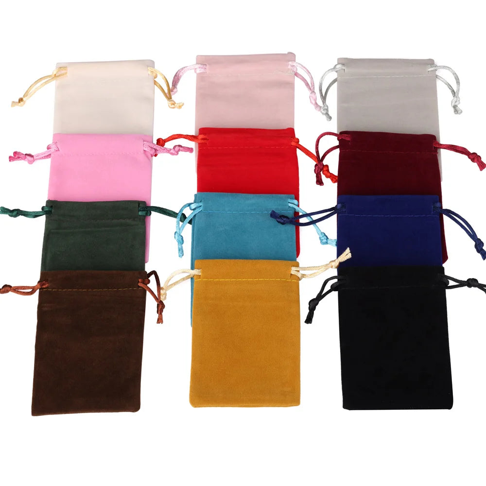 A collection of velvet drawstring jewelry gift bags in various colors including pink, red, blue, green, and black.