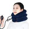 A woman is using a dark blue inflatable cervical traction neck stretcher pillow with a hose for neck stretching.