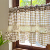 Beige gingham crochet lace curtain valance hanging in a window frame.