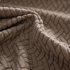 A close-up of a beige knitted fabric with a geometric pattern, likely a stretchy polar fleece sofa cover.