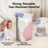 A white vacuum storage bag is shown next to a pink and blue bag, demonstrating tear-resistant and reusable material.