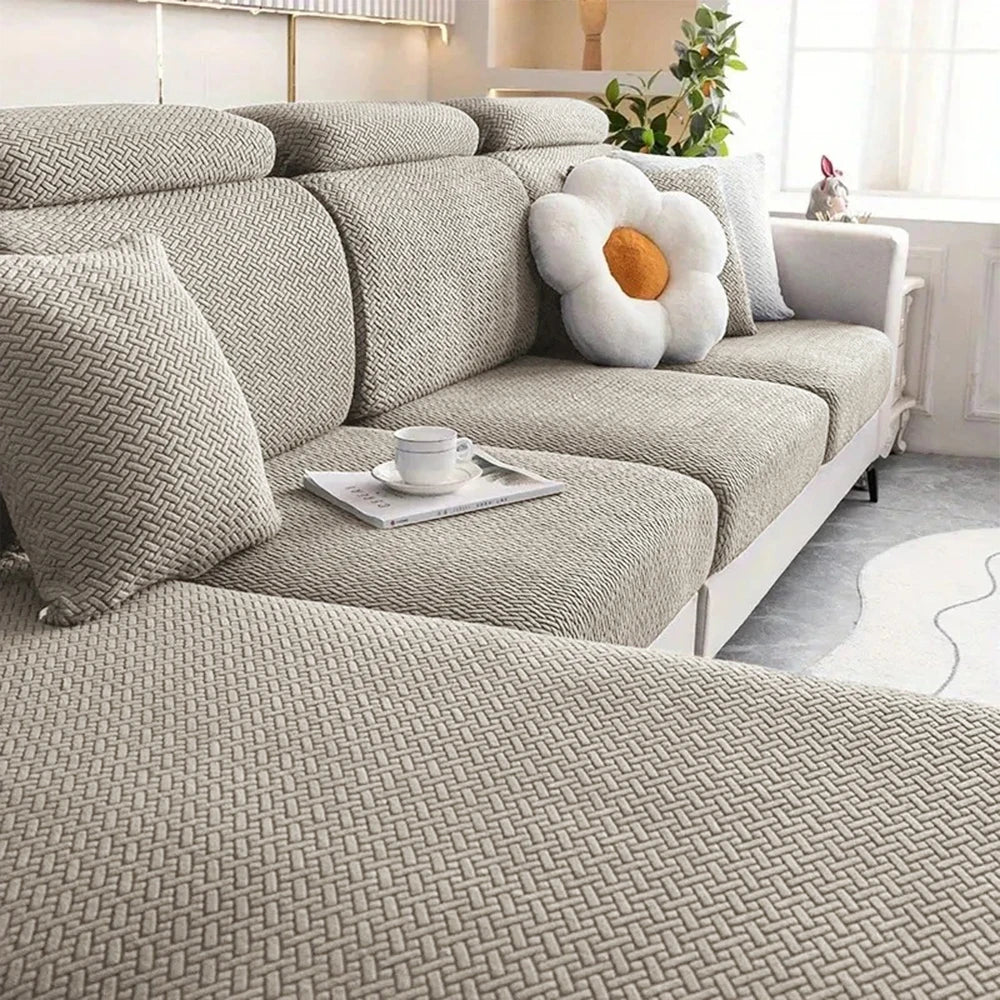 A light gray thick jacquard sofa seat cushion cover with decorative pillows and a white flower accent.