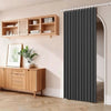 A dark gray pleated fabric door curtain hanging on a rod in a room with wooden shelving and cabinetry.