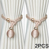 Two pairs of beige silk curtain tiebacks with gold accents and braided cord