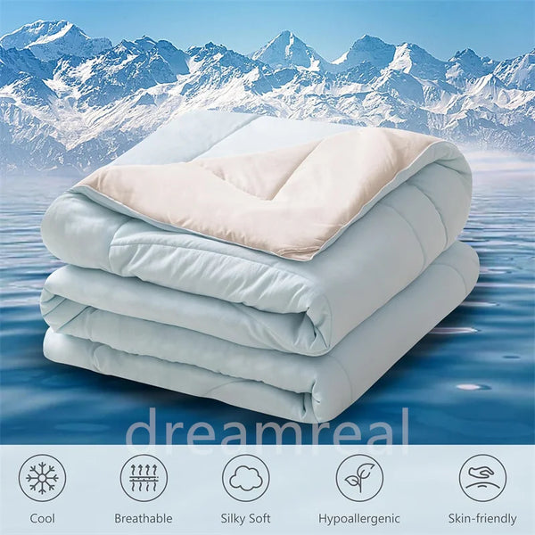 A stack of white and beige reversible cooling quilts with icons indicating features like cool, breathable, silky soft, hypoal