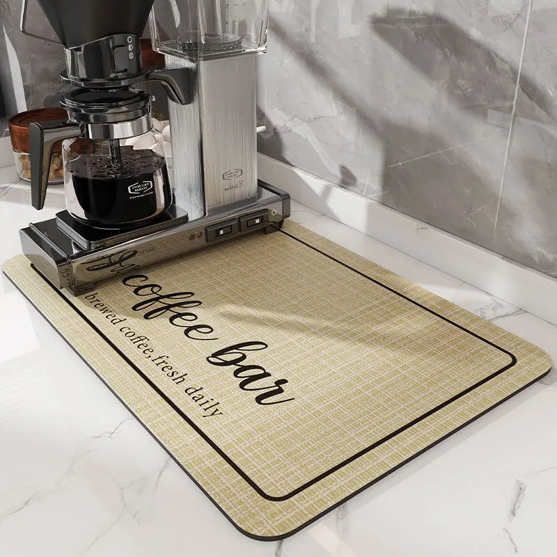A silver coffee grinder and glass carafe sit on a beige mat labeled brewed coffee fresh daily.