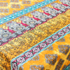 Yellow silk fabric with intricate pink and gray floral patterns and blue trim.