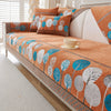 An orange and white patterned jacquard sofa seat and back cover with teal accents.