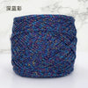 A ball of metallic silk yarn in various shades of blue, purple, and teal.