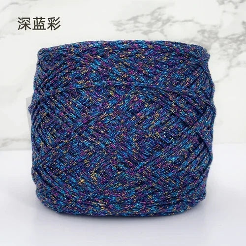 A ball of metallic silk yarn in various shades of blue, purple, and teal.