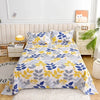 Light blue and yellow floral print flat bed sheets displayed on a bed with white bedding and wooden furniture.