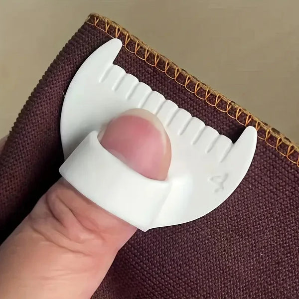 A hand holds a white precision stitch tool for knitting and sewing against a dark brown fabric background.