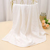 White printable cotton crib sheets draped over a gold hanger on a light surface.